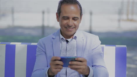 smiling mature man using cell phone outdoor