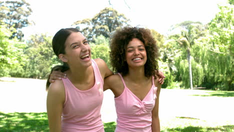 two friends wearing pink for breast cancer in the park