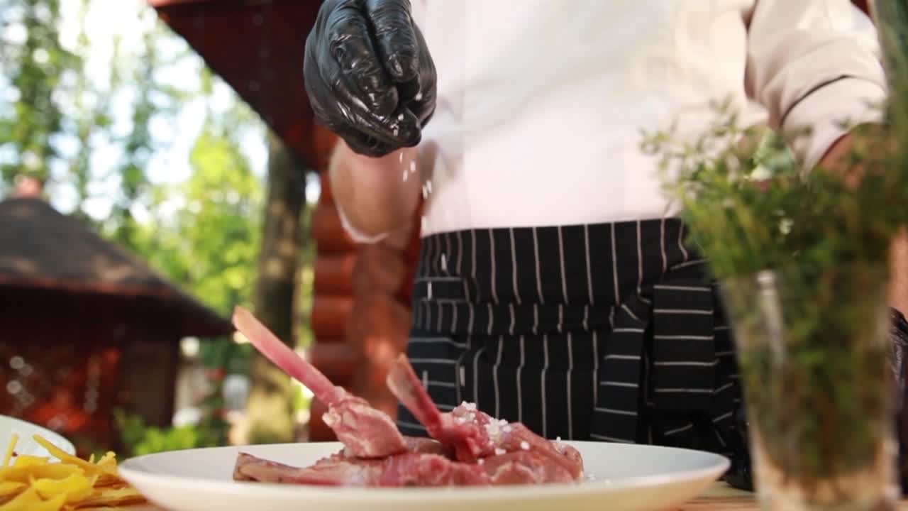 셰프가 야외에서 양를 맛보고 있습니다.