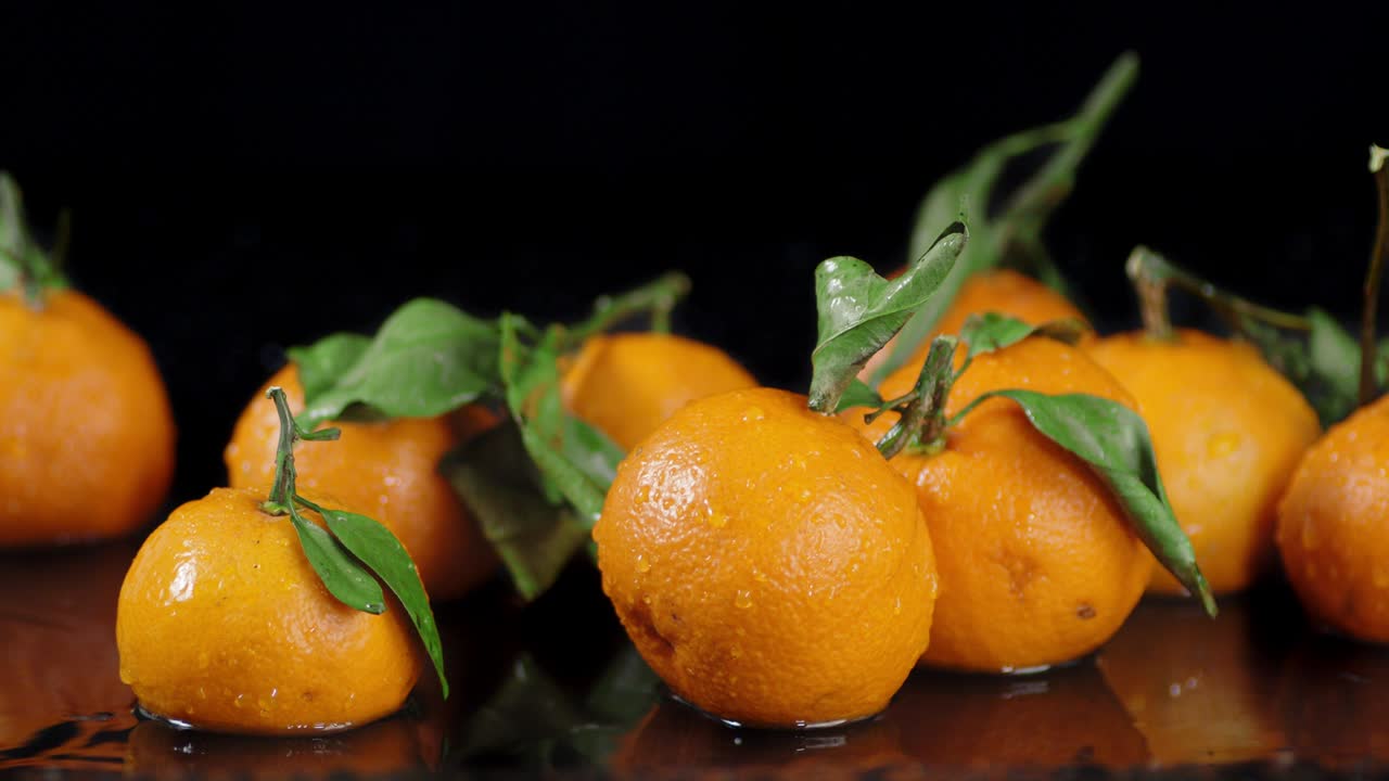 las mandarinas frescas con hojas son la mesa con agua.