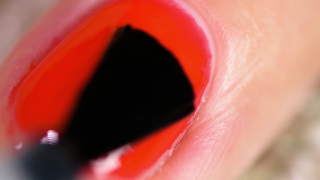 빨간 매니큐어에 래커 보호 층을 바르는 아마추어