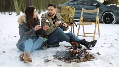 Caucasian-couple-camping-in-a-snowed-forest.