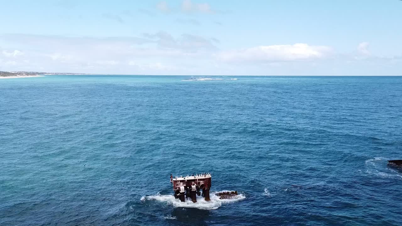 Static aerial view of shipwreck with sea birds and coastline of Western Australia