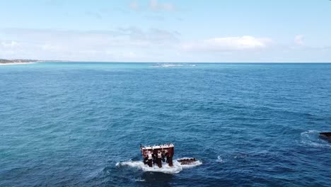 static aerial view of shipwreck with sea birds and coastline of western australia