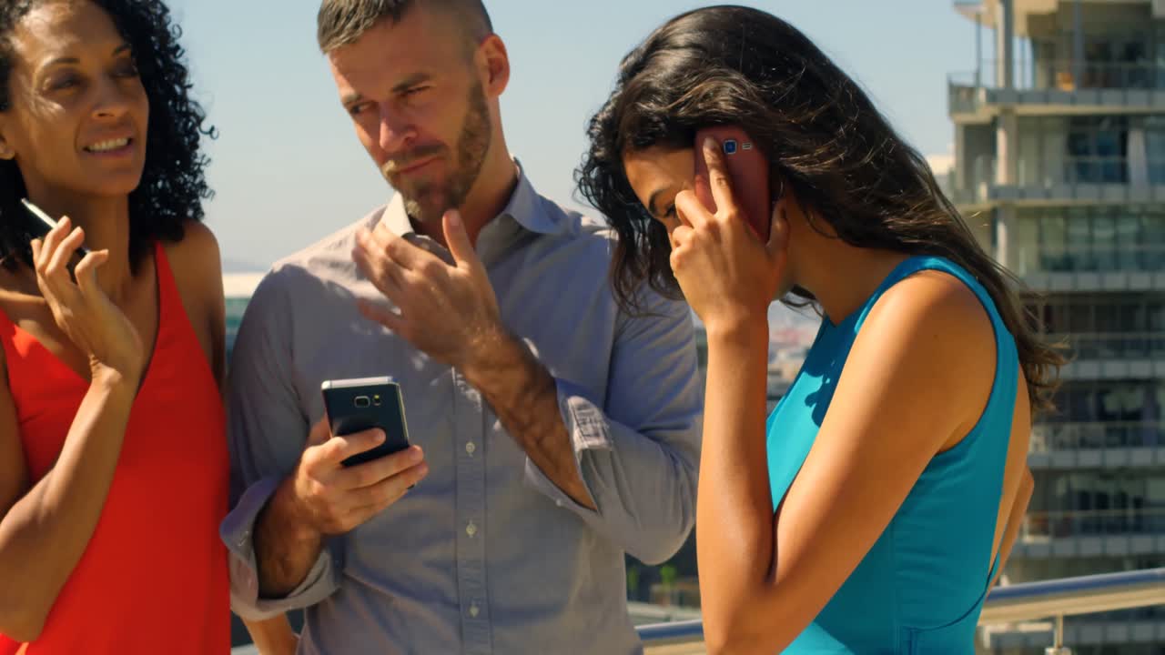 compañeros de trabajo que usan teléfonos móviles en oficinas 4k