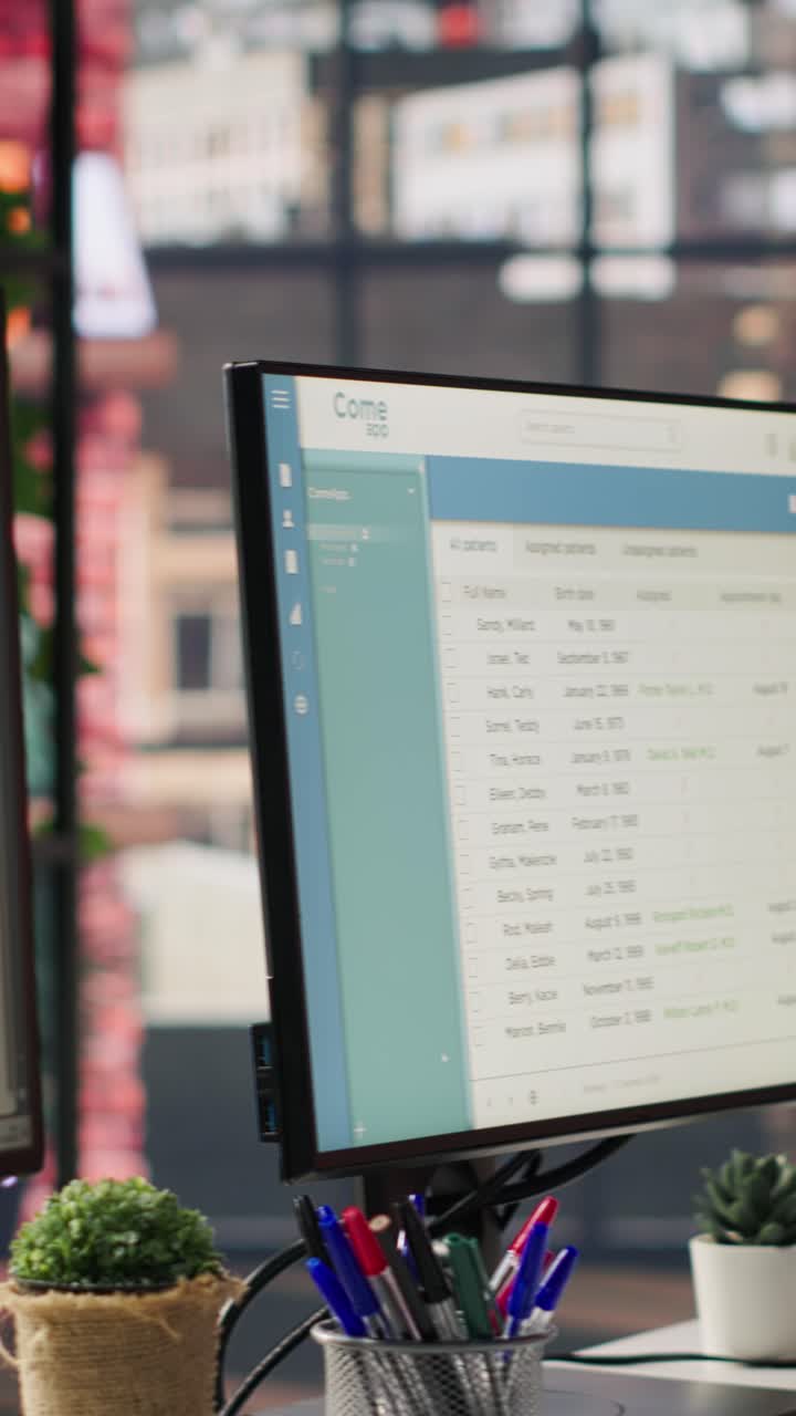 Vertical video Package tracking software and spreadsheets displayed on PC screens in office