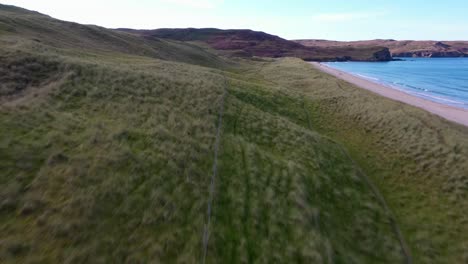 Low-flying-drone-shot-of-the-"Machair"-or-"seaside-grass-plain"-at-"Traigh-Mhor"-beach-in-Tolsta