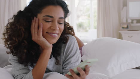 young-beautiful-woman-using-smartphone-texting-browsing-social-media-messages-enjoying-mobile-phone-communication-lying-on-bed-at-home-4k-footage