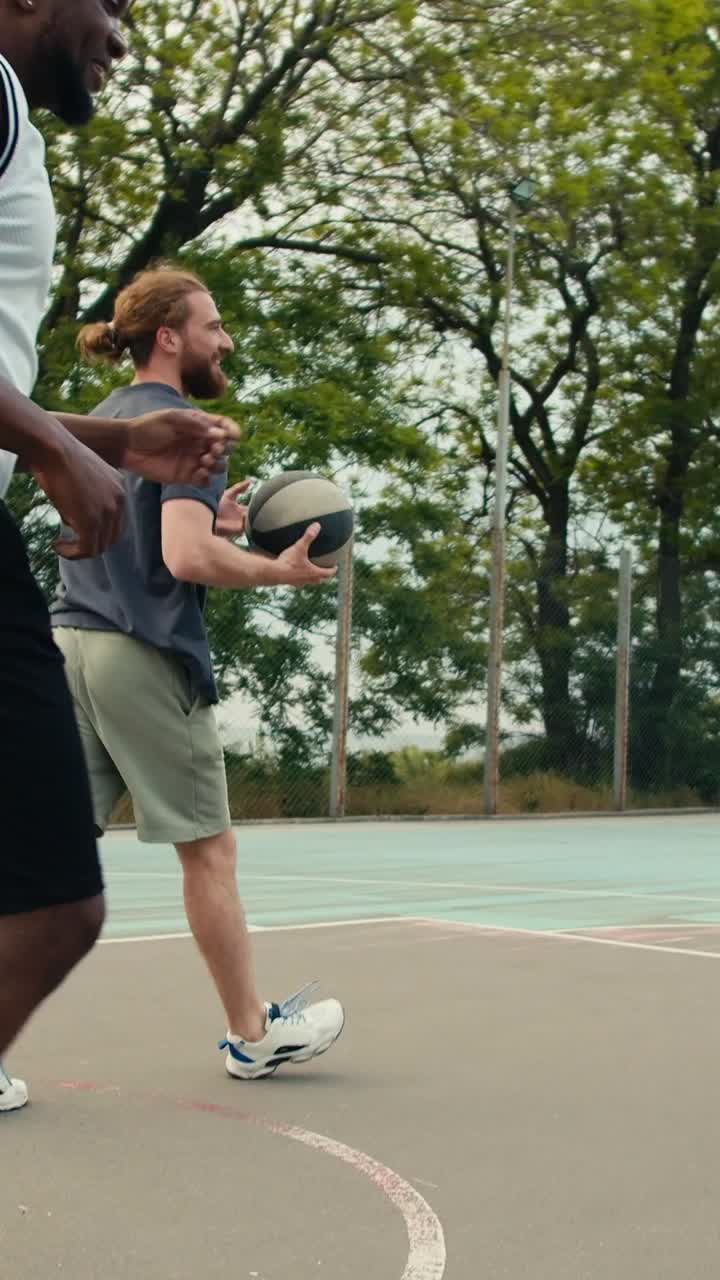 Two men playing basketball outside