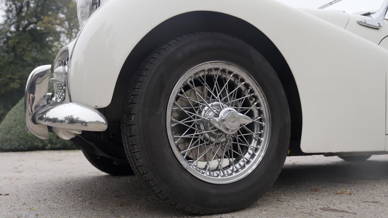 Close-up of a White Vintage Car's Wire Wheel and Fender