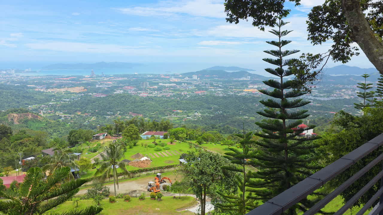 View of Kota Kinabalu with Terraced Hills From Kokol Hillside Cafe Showcasing Lush Greenery, Scattered Houses, and the distant Coastline - panning shot