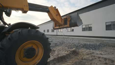 tractor moves rubble to truck. excavator-loader rakes rubble from pile at construction site and loads dump truck. clearing site