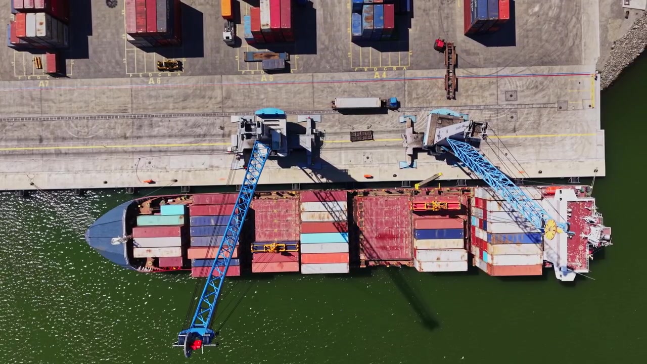 Cargo ship loading at port with cranes in action during daytime