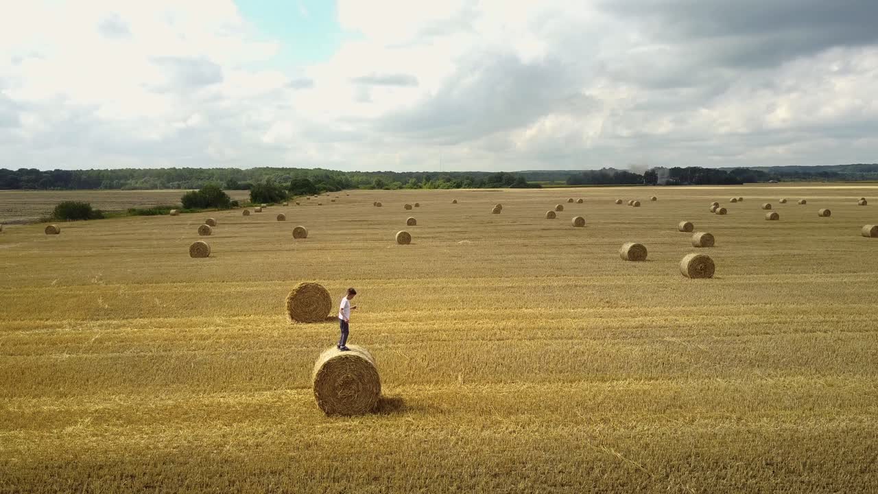 Child On A Field Against Straw. Happy child on a field with bales harvest
