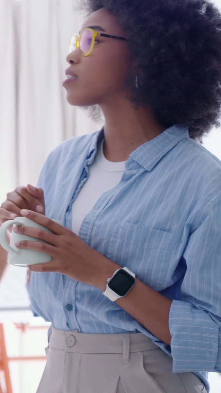 Vertical video: Turning to coworker entering, woman holding mug talking in kitchen in blue top