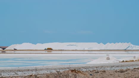 Camión-Cargado-De-Sal-Conduciendo-Por-El-Salar-En-Bonaire,-Países-Bajos-En-Un-Día-Soleado---Toma-Amplia