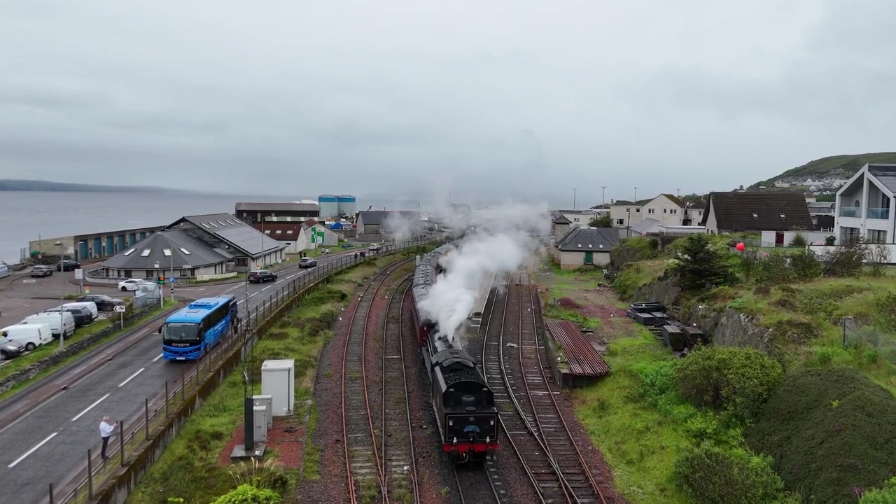 Vista drone della città costiera e del porto peschereccio di Mallaig con barche ormeggiate lungo la banchina sulla costa occidentale delle Highlands scozzesi.