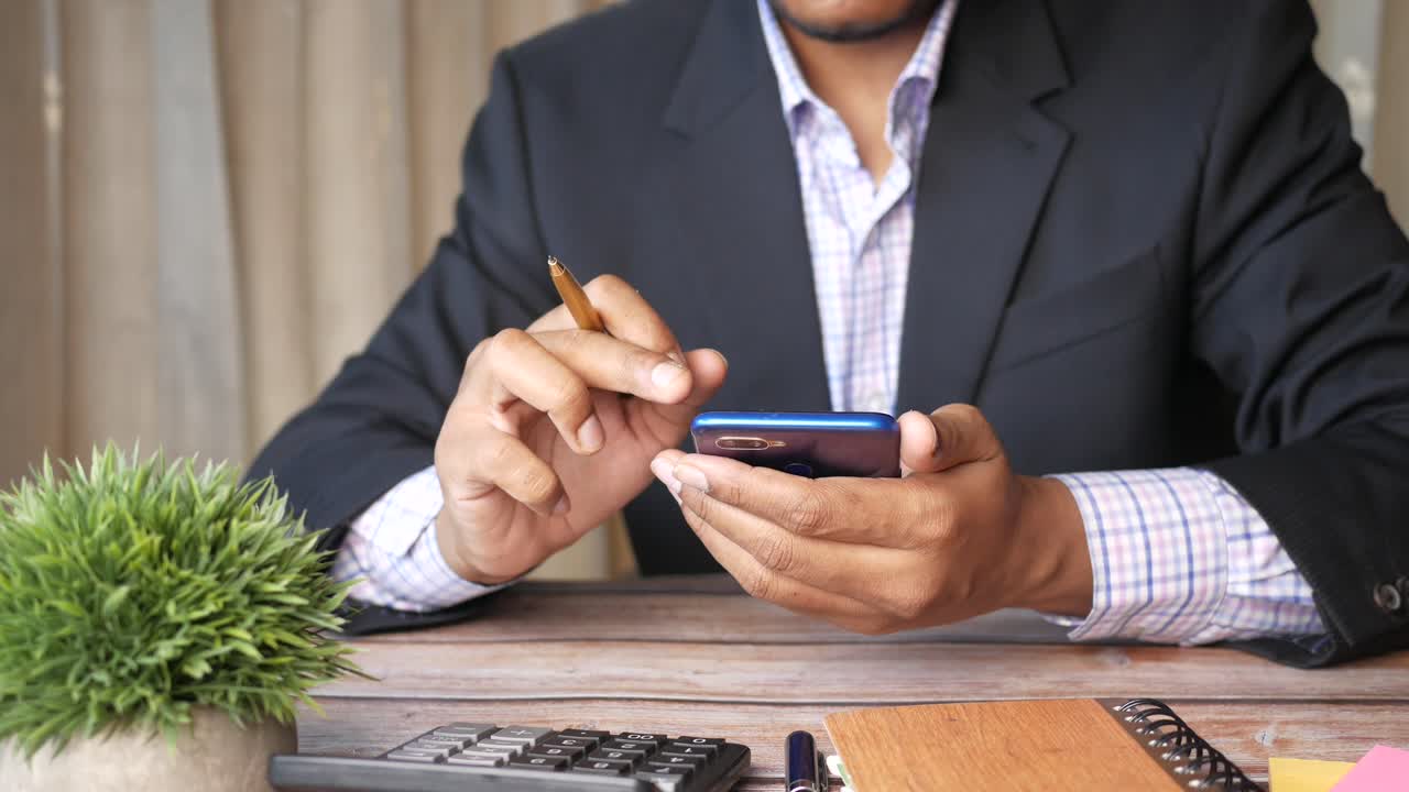 hombre de negocios usando un teléfono inteligente en el escritorio