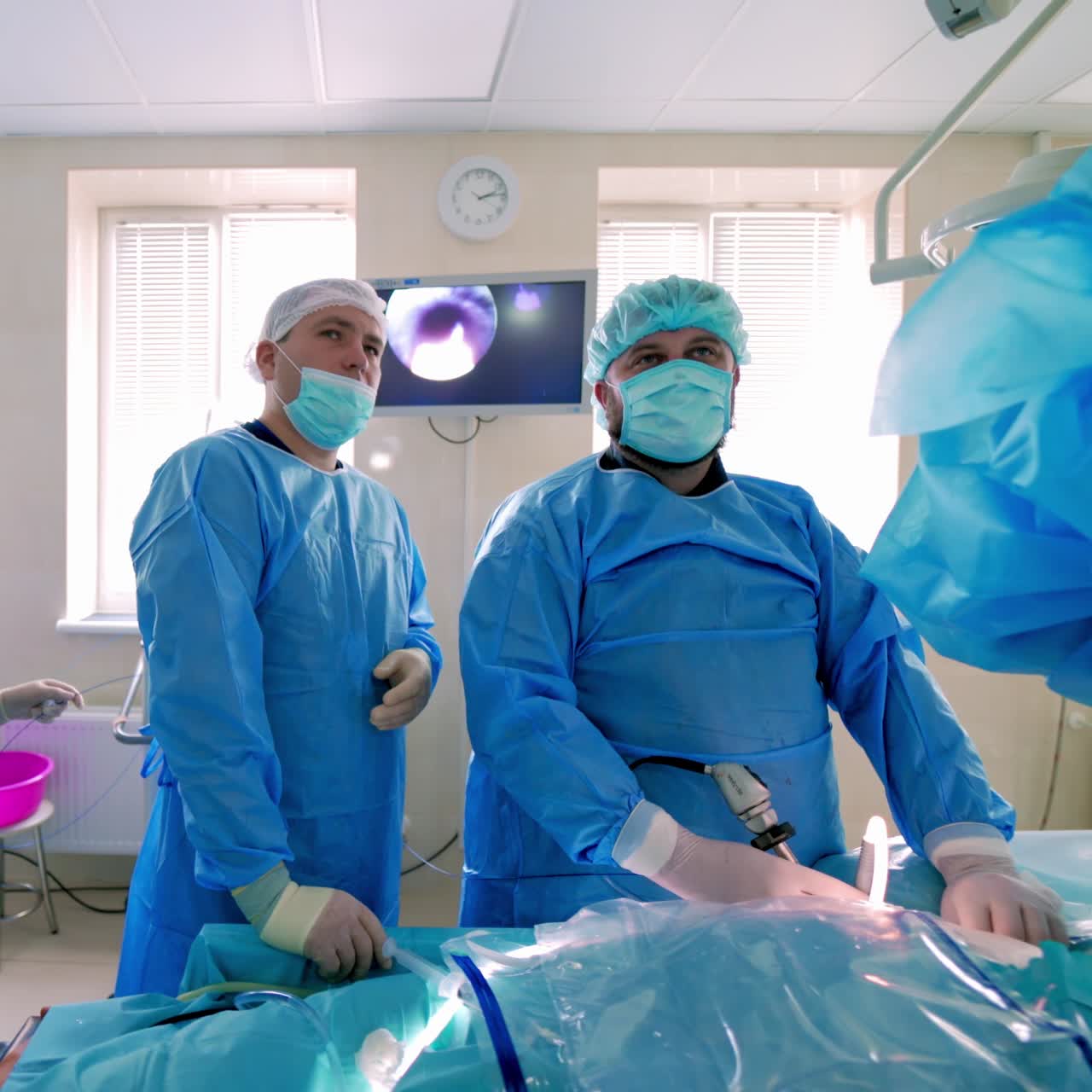 Professional surgeons operate the patient. Doctors in medical uniform and masks performing a surgery using modern medical equipment. Healthcare concept.