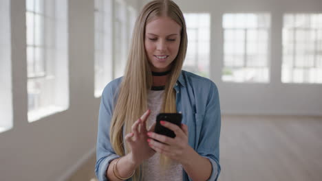 Retrato-En-Cámara-Lenta-De-Una-Hermosa-Joven-Rubia-En-Un-Nuevo-Apartamento-Enviando-Mensajes-De-Texto-Navegando-Usando-Tecnología-Móvil-De-Teléfono-Inteligente-Feliz-Emocionado