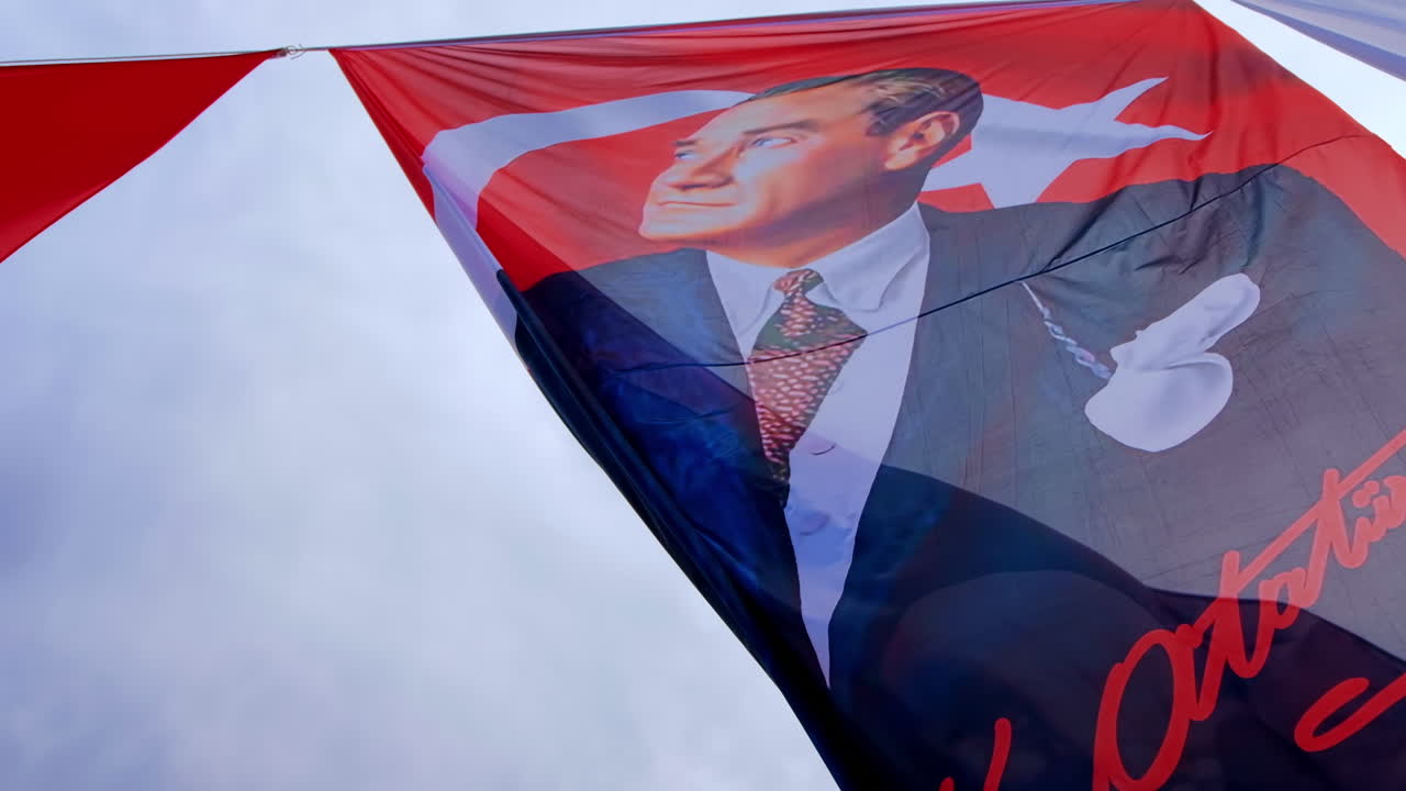 La bandiera nazionale turca con il ritratto di Mustafa Kemal Atatürk che sventola al vento ad Antalya, in Turchia