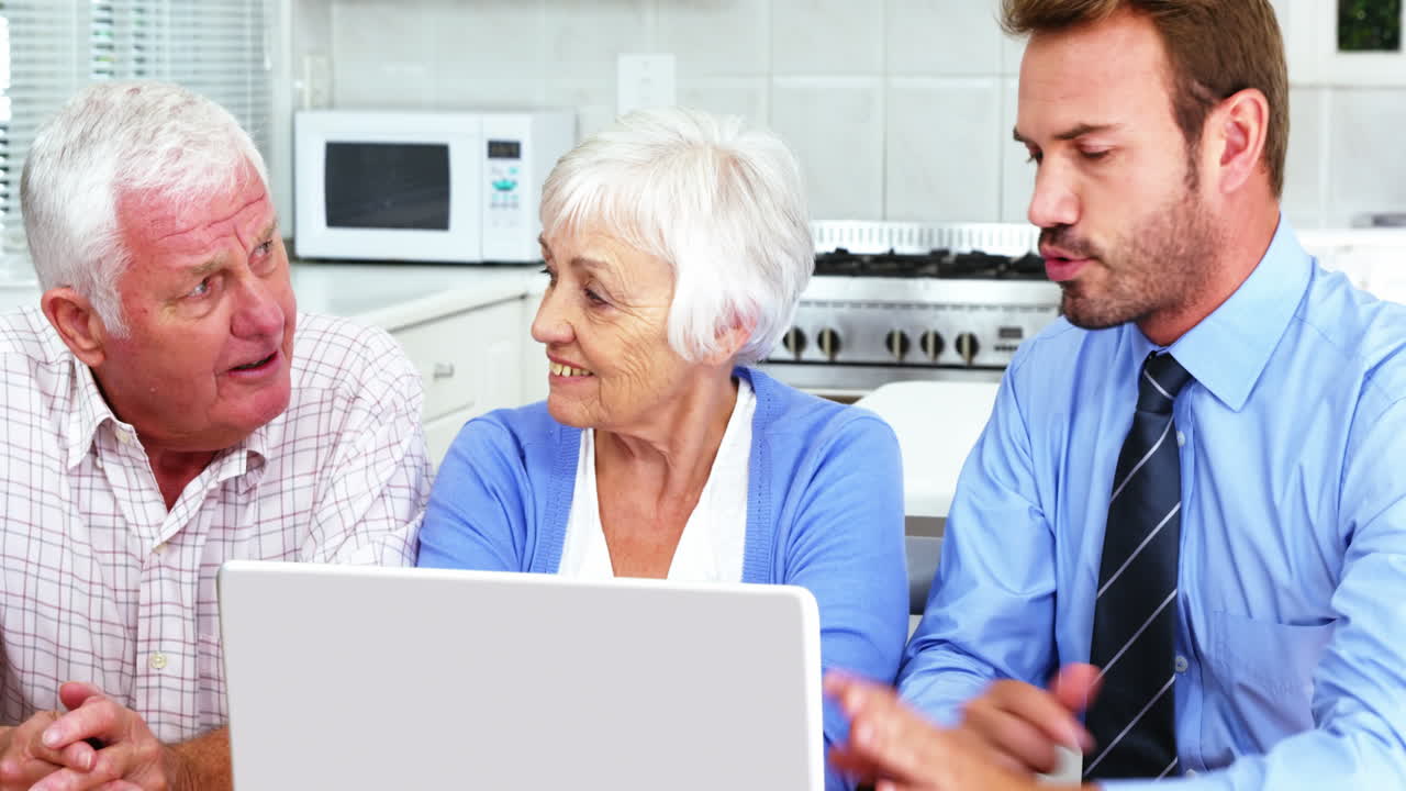 Mature couple looking a laptop with a businessman 