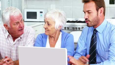 Mature-couple-looking-a-laptop-with-a-businessman-