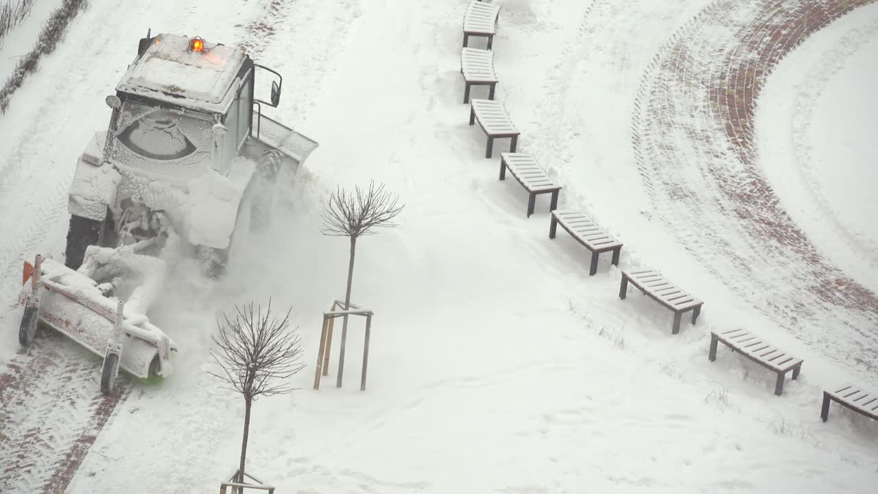 트랙터 굴착기는 도시 마당의 눈을 제거합니다. 공공 시설 업무