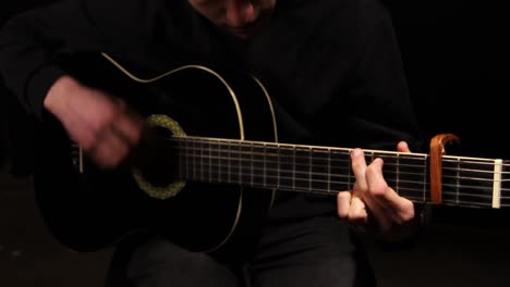 studio shot of man playing his guitar