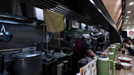 chef cooking ramen in a busy kitchen