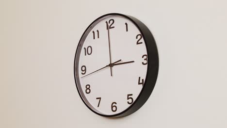 a detailed close-up of a wall clock with a black frame and white face, displaying the time at 3:00.