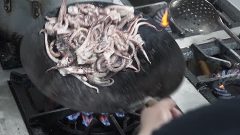 Chef-Lanzando-Pulpo-En-Un-Wok-A-Fuego-Alto,-Acción-De-Cocina