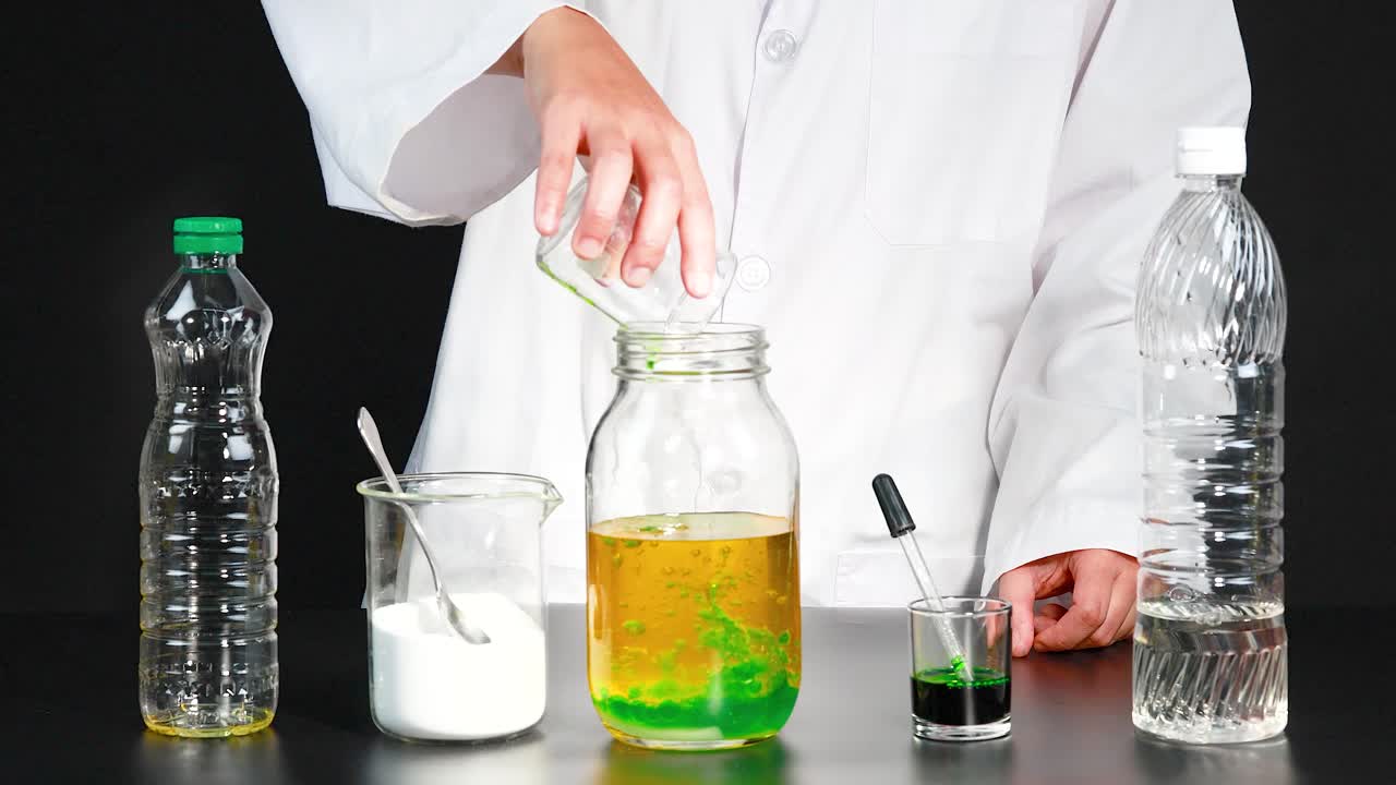 los niños crean una lámpara de lava casera usando aceite, agua y tinte en un entorno de laboratorio, demostrando reacciones químicas