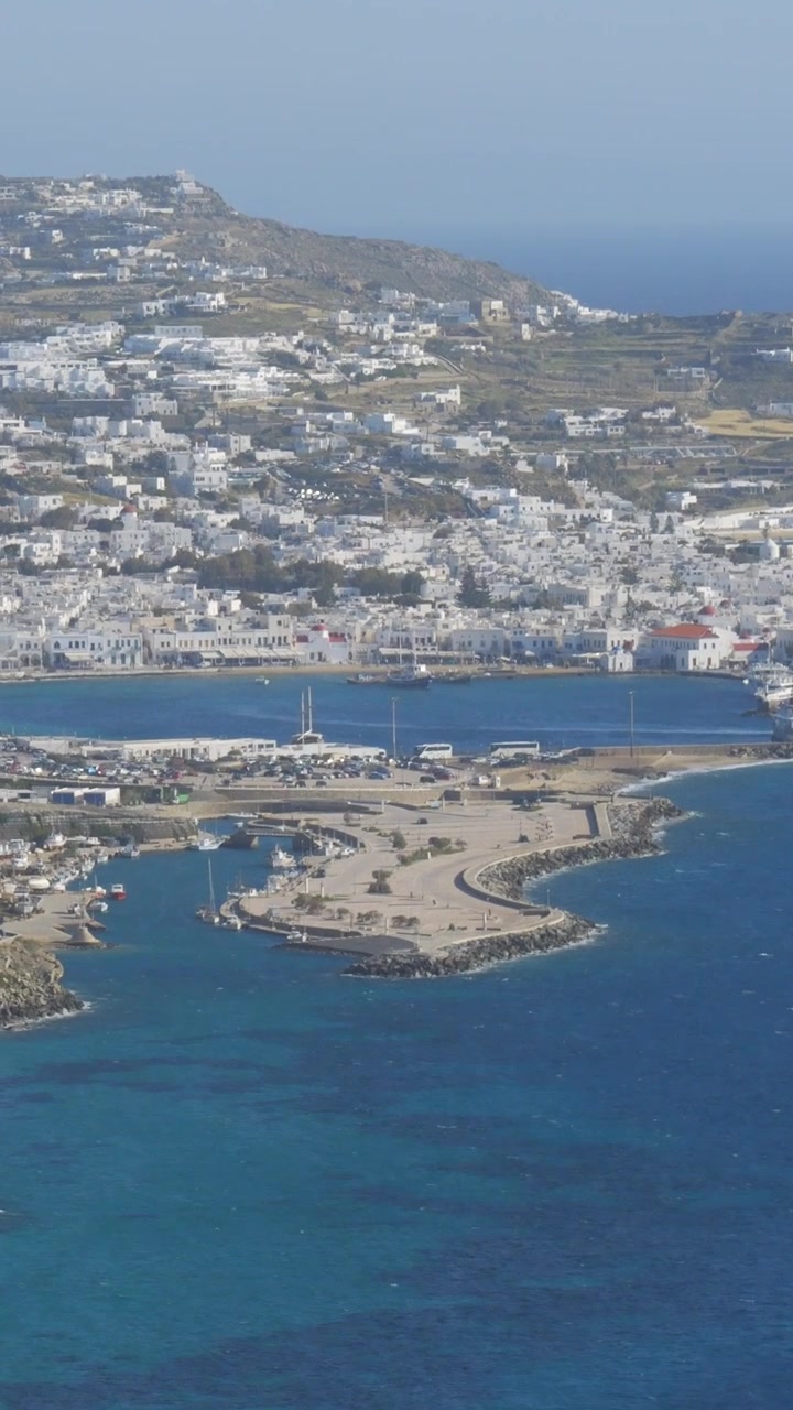 Vista verticale di un porto turistico con barche e una città costiera che si affaccia sul Mar Egeo sull'isola di Mykonos, Grecia