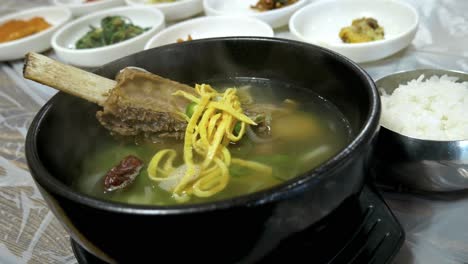 steaming hot korean beef bone soup in a rock bowl