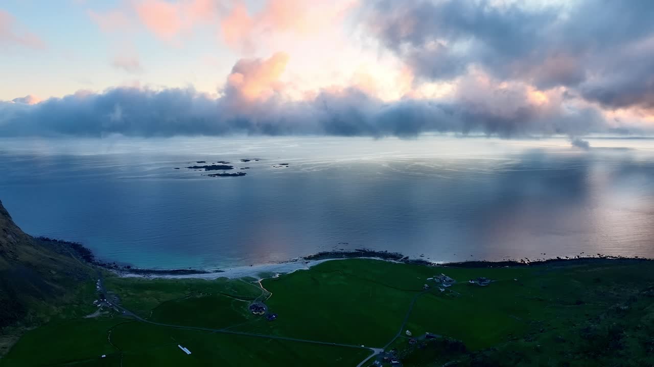 Dramatic midnight sun and clouds above Utakleiv beach in Lofoten, subtle sideways drone move