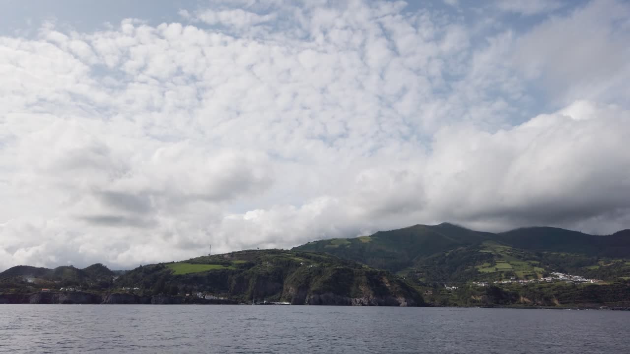 costas del sur de la isla de san miguel, azores, portugal, filmado desde un barco con las olas del océano en primer plano