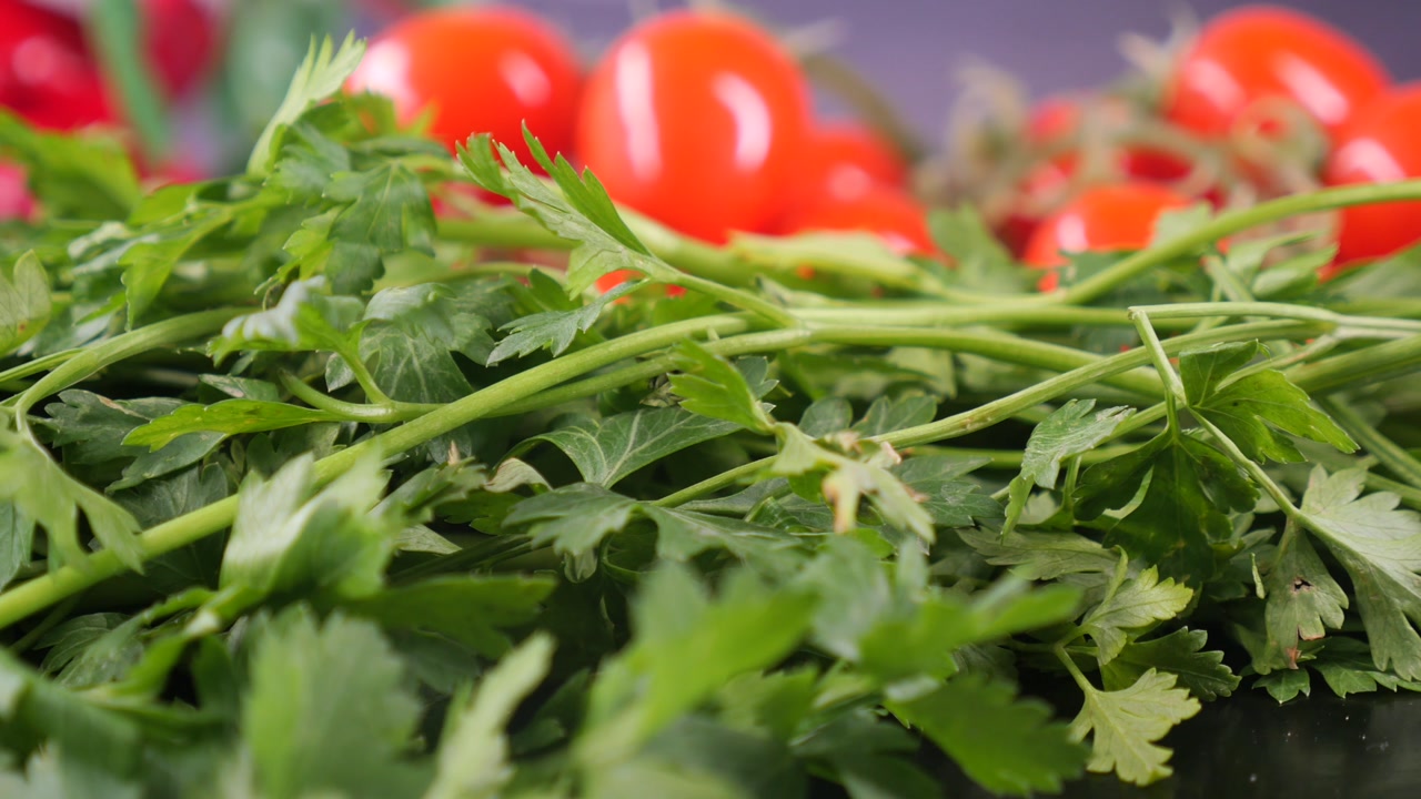 Fresh Green Parsley Leaves with Blurry Tomatoes in Background