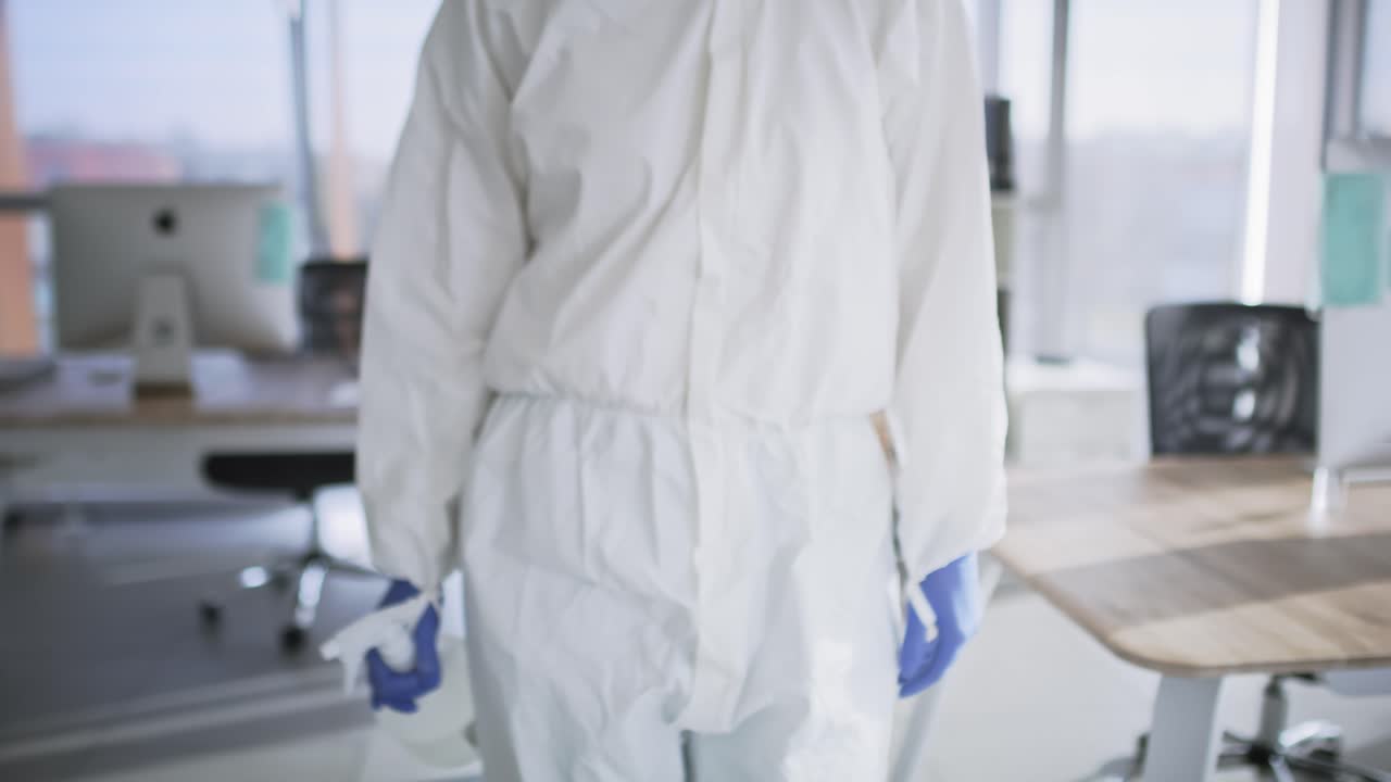 vídeo de una persona con ropa de trabajo protectora caminando por la oficina