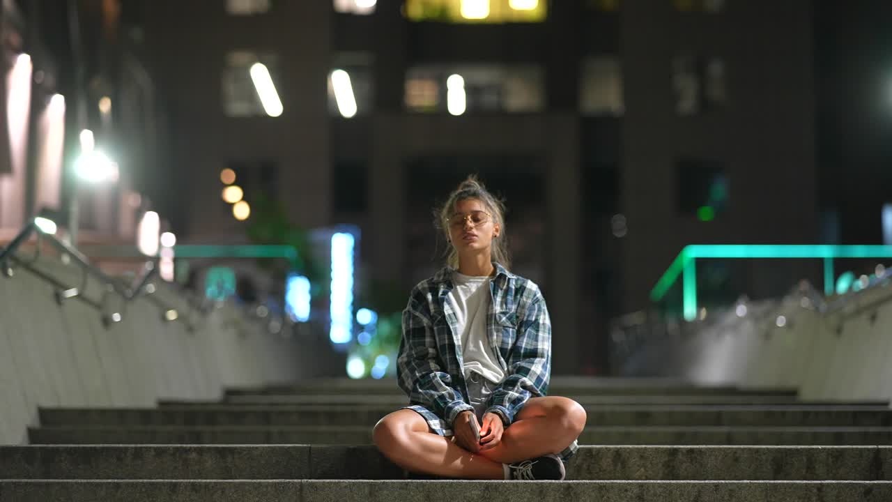 mujer sentada en las escaleras por la noche