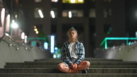 mujer sentada en las escaleras por la noche