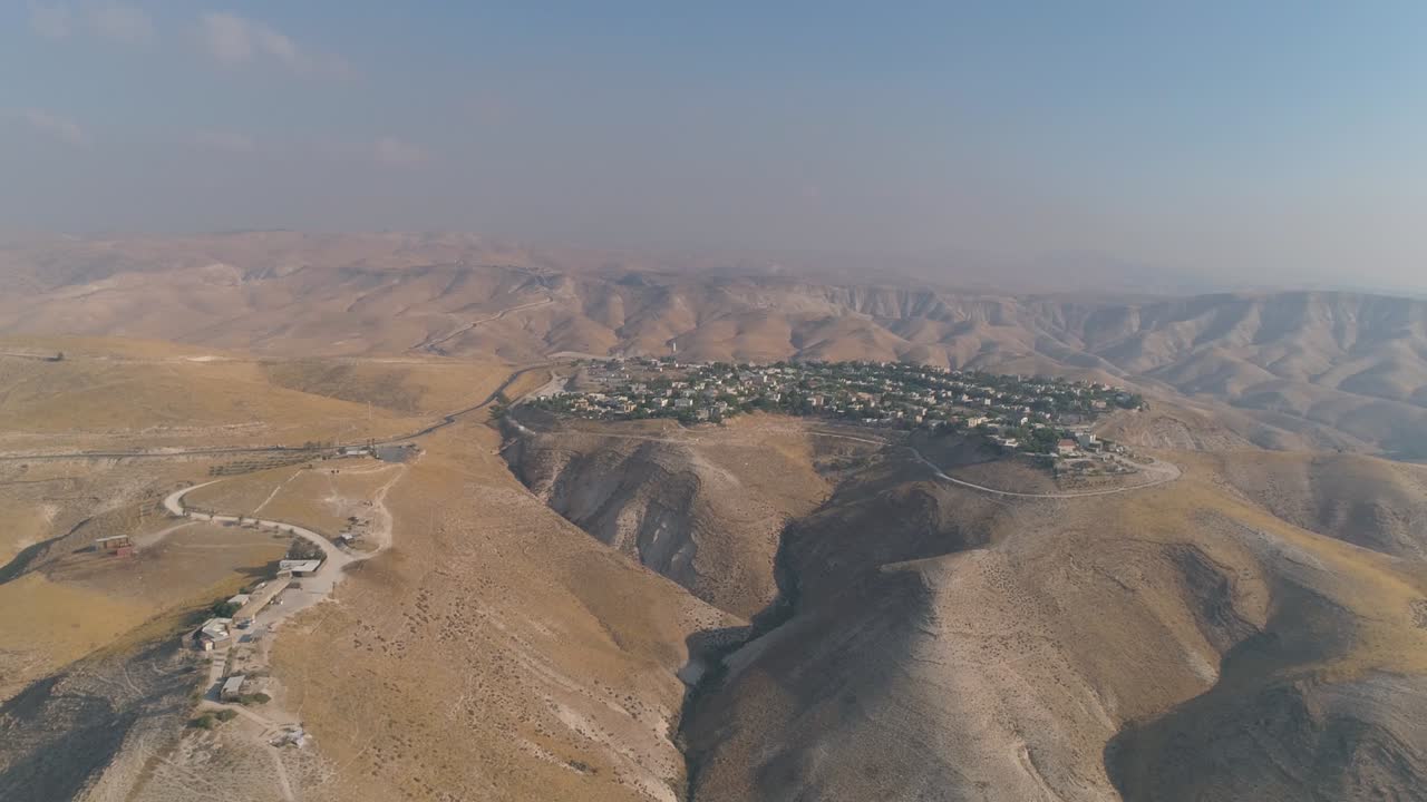 Insediamento ebraico nel deserto della Giudea e della Samaria in Israele. Vista aerea con drone di case di villaggio su cime di montagne. Vita mediterranea all'aperto in coesistenza.