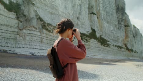 woman taking photos on a beach by white cliffs of dover