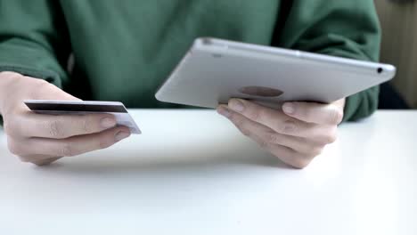 manos femeninas sostienen una gran tableta y tarjeta de crédito, banca en línea, compras 60 fps
