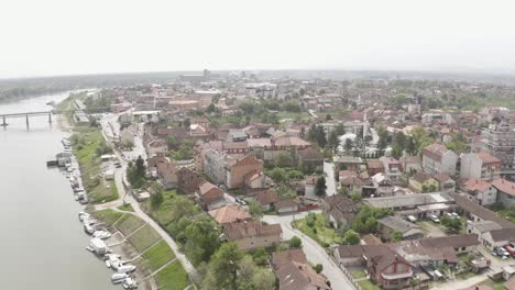 Reenviar-El-Dron-Para-Filmar-El-Hermoso-Río-Sava-En-El-Distrito-De-Brcko-De-La-Pequeña-Ciudad-En-Bosnia-Y-Herzegovina,-Muy-Bonito-Y-Costa-De-Troncos