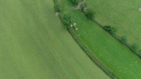 Antena-De-Arriba-Hacia-Abajo-De-Un-Tractor-Segando-Un-Campo-Angosto-Entre-Campos-Mucho-Más-Grandes