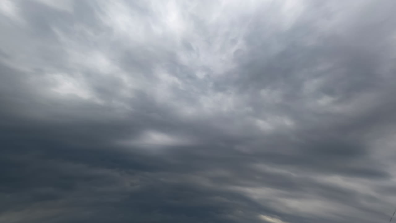 Thick dramatic cloudscape spreading in the atmosphere. Low angle view on the rainy clouds in the sky. Timelapse.