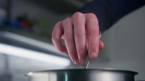 chef cook stirs delicious dish in a pot by spoon