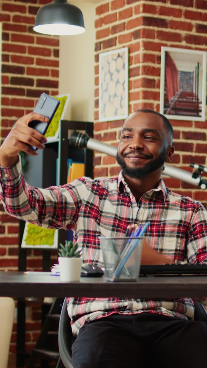 Uomo che si fa un selfie nel suo ufficio domestico