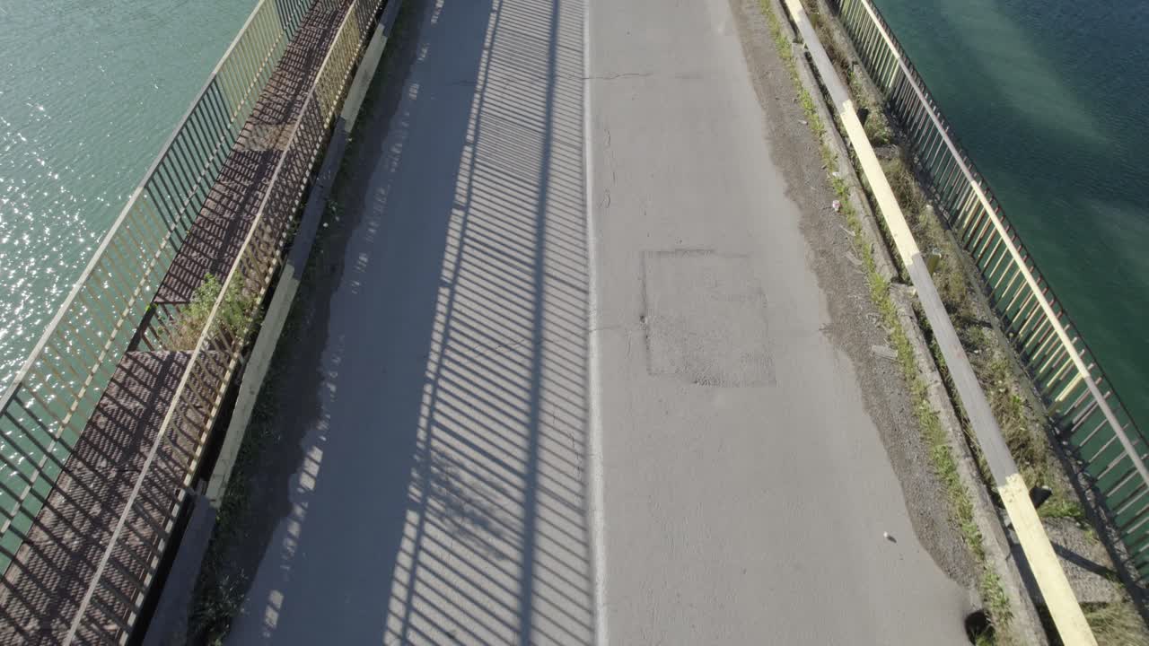 맑고 화창한 아침에 루마니아의 호수 위의 트랜스알피나 고속도로 다리